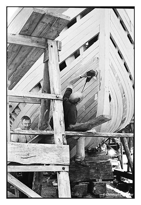 Photo noir et blanc "Le langoustier-2". Ponçage et finition de la coque en bois du langoustier sur le port de Douarnenez.© Juillet 2010 Christophe Letellier tous droits réservés.