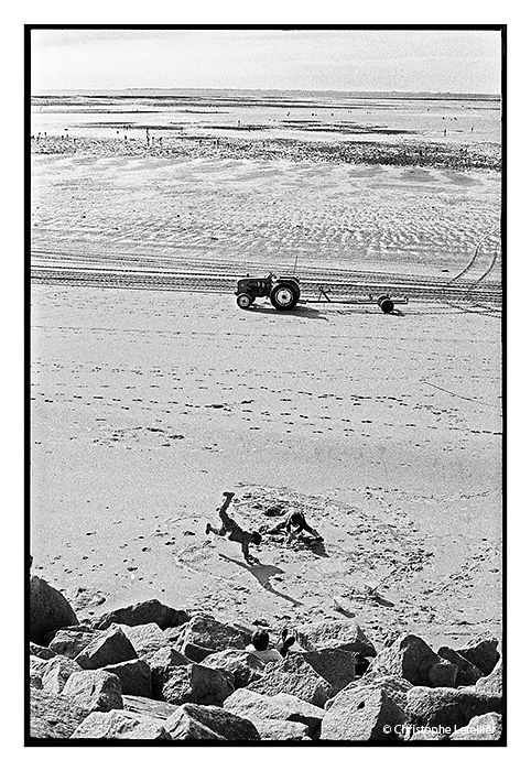Jeux de plage. Photo noir et blanc de jeunes enfants s'amusant sur la plage de Saint Martin de Bréal dans le département de La Manche.© 2003 Christophe Letellier tous droits réservés. Reproduction interdite. 