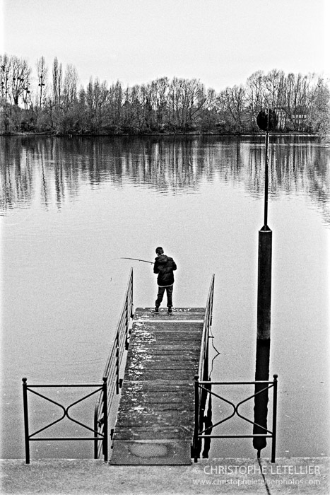Photo en noir et blanc d'un enfant armant sa canne à pêche sur les bords de rives de La Seine aux Andelys dans l'Eure. © 2016 Christophe Letellier all rights reserved. 